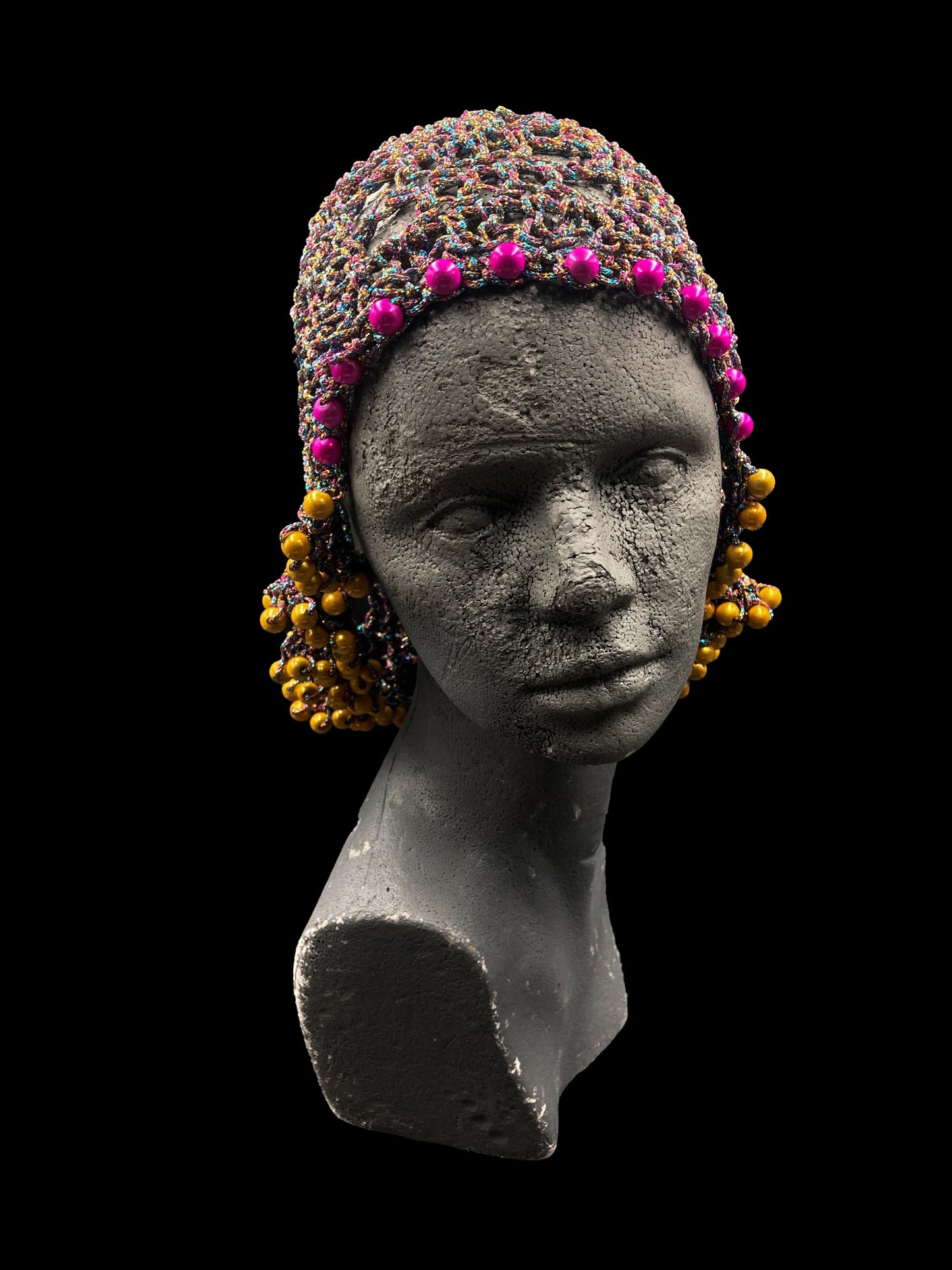 Handmade crochet headwear features a bold mullet-inspired design, shiny blue pink and yellow, with yellow and pink beads. Designed for a unisex fit, one size fits all.
