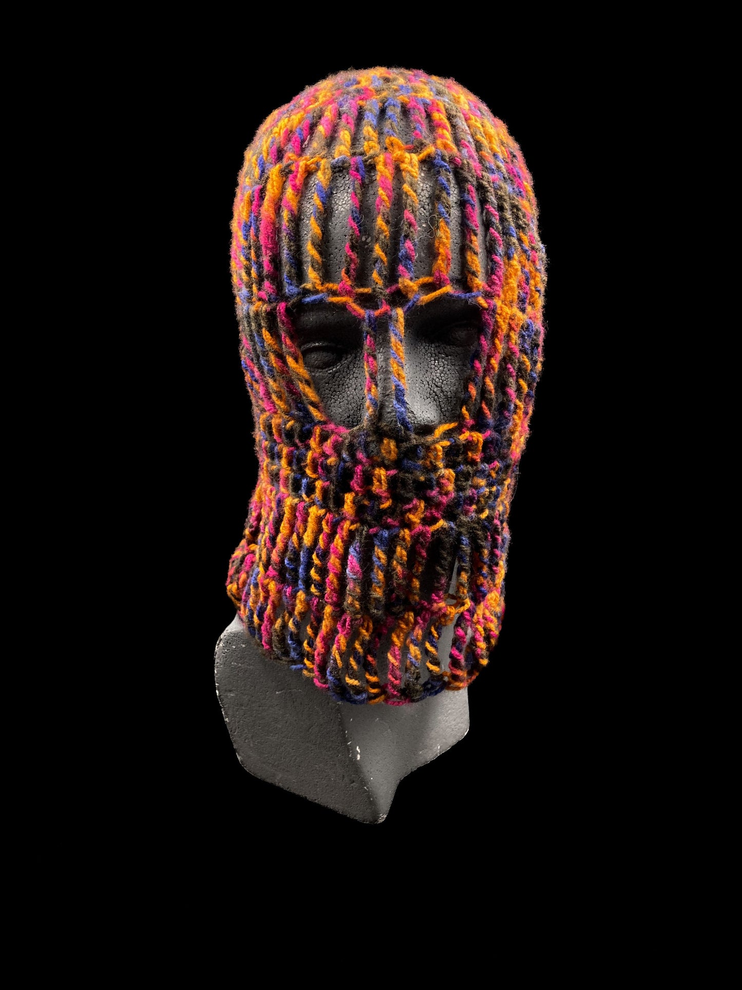 Handmade crochet balaclava with an open-eye design, featuring a bold mix of black, orange, pink, and blue. Unisex, one size fits all